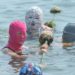 Caldo record in Cina, tra i bagnanti spopola il ‘facekini’