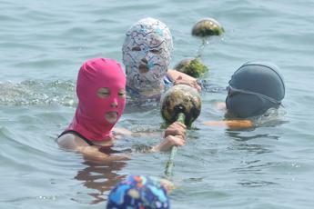 Caldo record in Cina, tra i bagnanti spopola il ‘facekini’