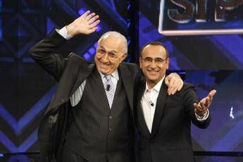 Baudo, Conti ricorda il grande conduttore: “Lui è la tv, indimenticabili i suoi abbracci paterni”